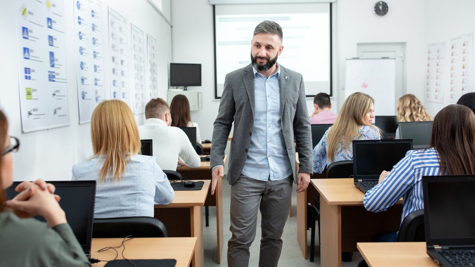 Instructor acompañando a participantes en un aula