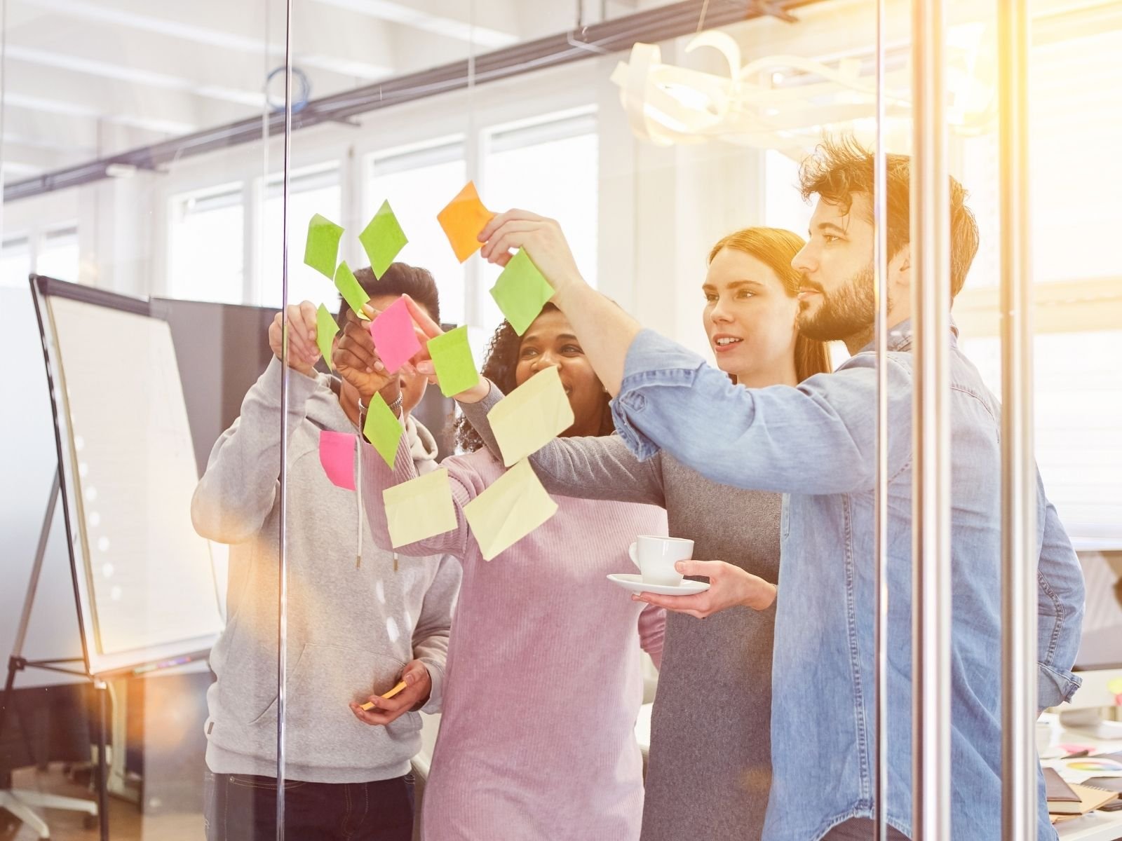 Equipo colaborando con notas adhesivas en una sesión de ideas